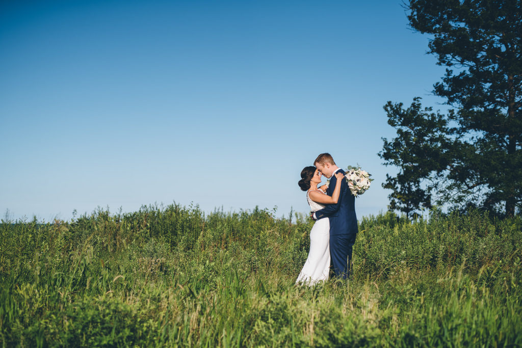 A bride and groom stand together in a beautiful field for Chicago wedding photos with Ed and Aileen Photography. 