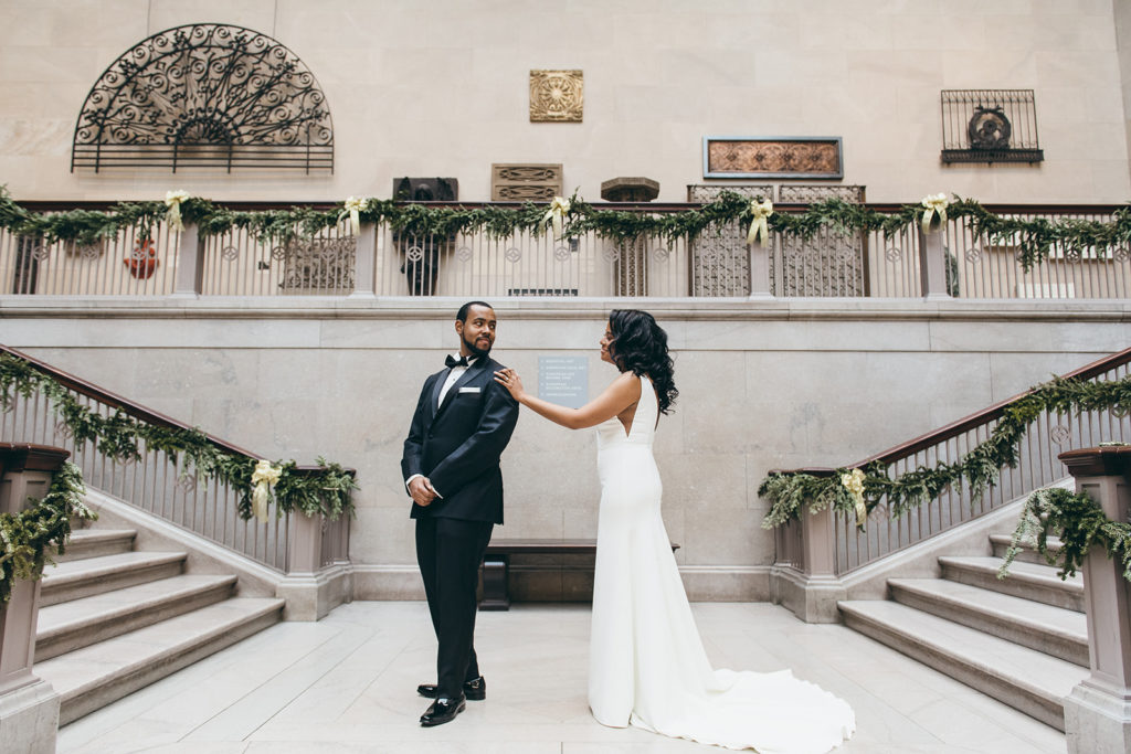 A bride and groom have their first look during their wedding at the Art Institute of Chicago, while Ed and Aileen Photography capture the moment at one of the best Chicago photo spots.