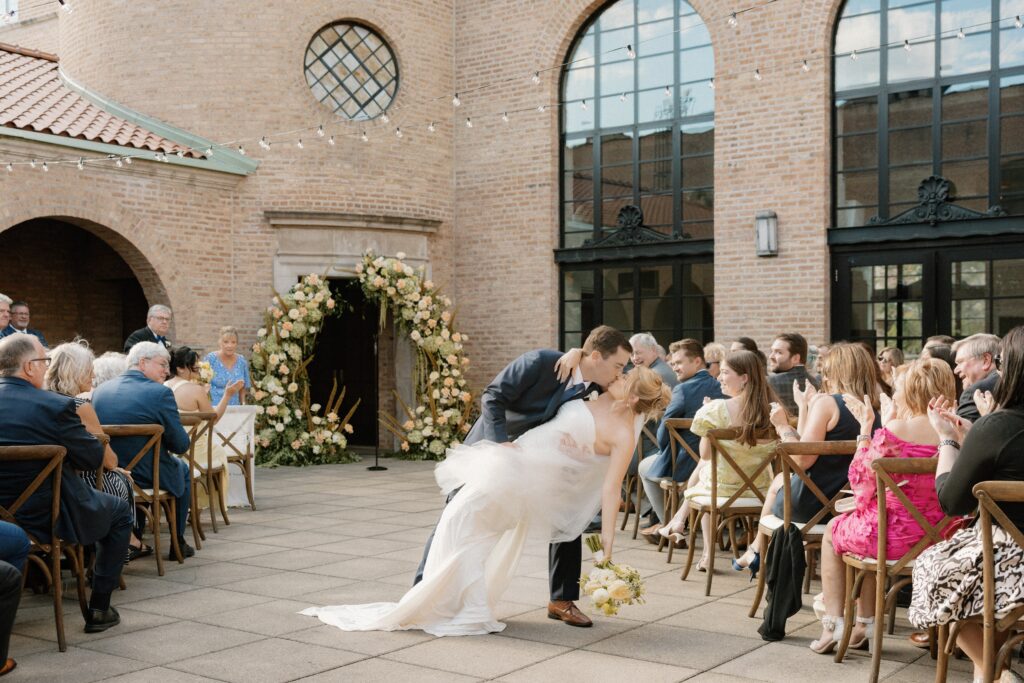 Bride and groom kiss at wedding ceremony in Chicago at Revel Motor Row
